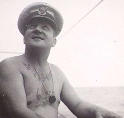 Военный моряк с жетоном на шее.