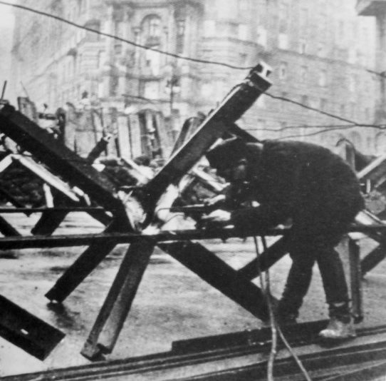 Рабочий соединяет заграждения перед баррикадой на перекрестке улиц Большой Дорогомиловской и Раевского. Зима 1941 г.