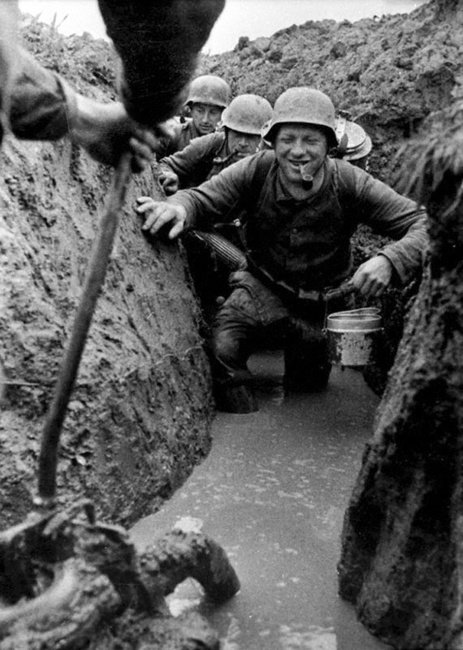 Солдаты в залитых водой окопах разносят пищу. Район Великих Лук. Октябрь 1943 г.