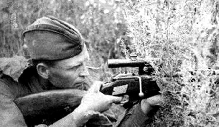 Снайпер П. Гончаров на боевой позиции с именной винтовкой.