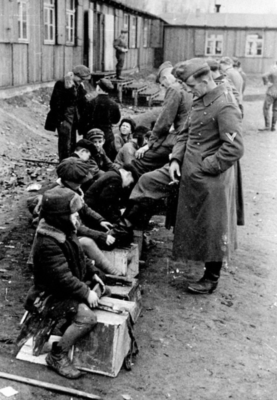 Дети чистят обувь солдатам.
