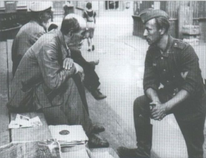 Торговец граммофонными пластинками беседует с немецким солдатом.