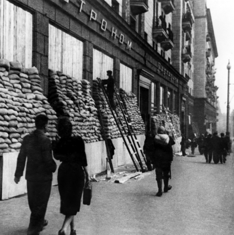 Рабочие закрывают мешками с песком стеклянную витрину гастронома на улице Горького. Октябрь 1941 г.