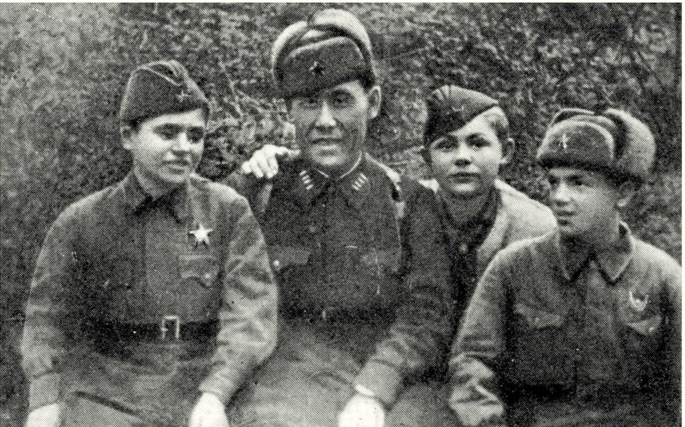 Командир 395-й дивизии С. Рахимов (в центре) с юными бойцами. Слева направо: разведчик Женя Зелинский, снайперы Женя Суворов и Вася Курка. 1942 г.
