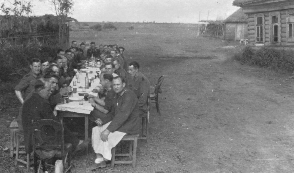 Немецкие солдаты за столом на улице оккупированной советской деревни.