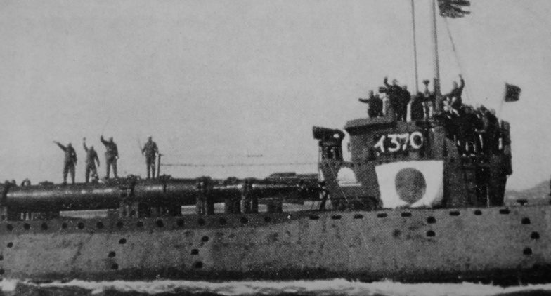 Японская подводная лодка I-37 выходит в боевой поход с человекоуправляемыми торпедами «Кейтэн», на которых (cлева) стоят пилоты-смертники с мечами и с повязками на головах. 1945 г. 