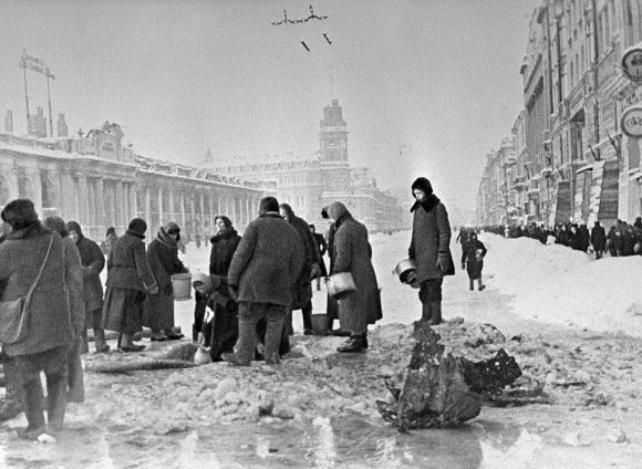 Жители города набирают воду, появившуюся после артобстрела в пробоинах в асфальте на Невском проспекте. 1 декабря 1941 г.