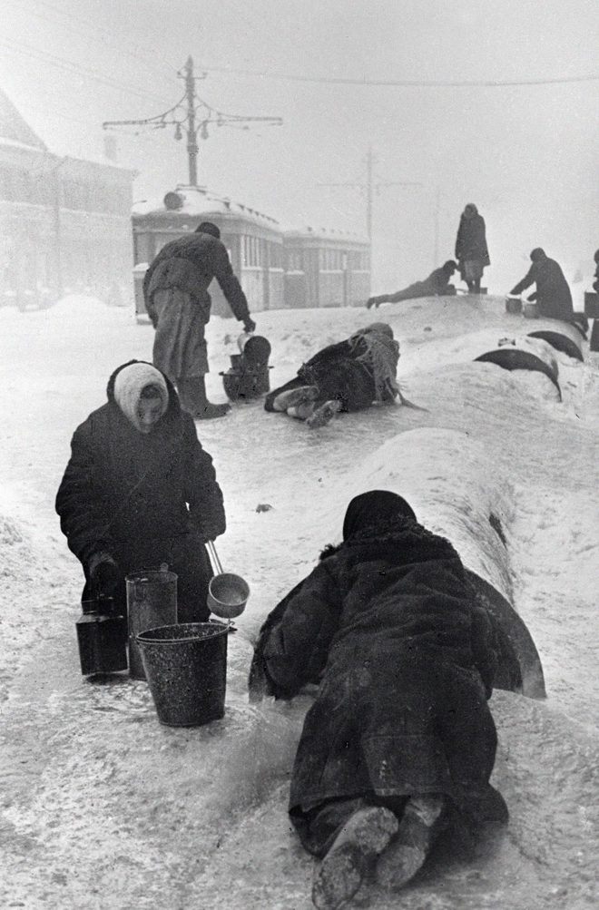 Жители Ленинграда набирают воду из разбитого водопровода на обледенелой улице. 1 января 1942 г.