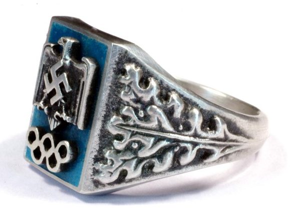 Перстень посвящен олимпийским играм, прошедшим в Германии в 1936 г. Он изготовлен из серебра 800-ой пробы с применением горячей цветной эмали.