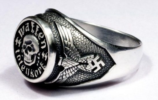 Основной элемент кольца представляет собой череп поверх двух скрещенных костей. На щитке надпись - надпись: «Waffen SS». По краям щитка расположены имперские орлы. Кольцо изготовлено из серебра 830-ой пробы с применением чернения. 