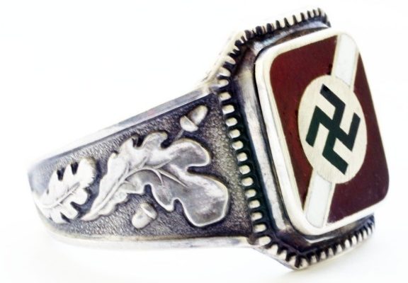 Перстень Латышского добровольческого легиона СС изготовлен из серебра 900-ой пробы с использованием цветной горячей эмали. По сторонам щитка наложен традиционный орнамент из дубовых листьев.