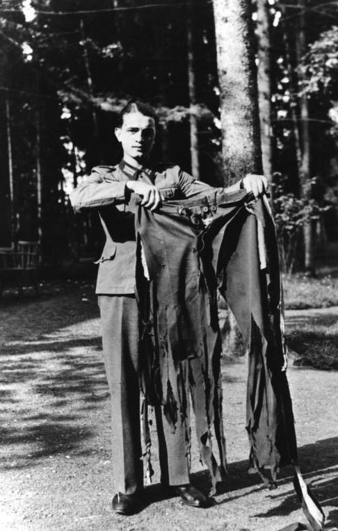 Солдат демонстрирует штаны и китель фюрера, чудом уцелевшие при взрыве. 1944 г.