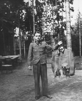 Солдат демонстрирует штаны и китель фюрера, чудом уцелевшие при взрыве. 1944 г.
