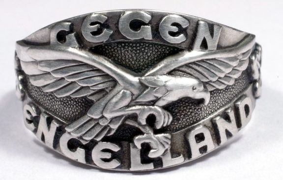Наградное кольцо за основу дизайна щитка, которого, взят текст «Gegen Engeland» (На Англию) и эмблема Люфтваффе. Кольцом награждались пилоты-истребители, участвовавшие в «Битве за Англию» в 1940 году. Кольцо выполнено из серебра 835-ой пробы с применением чернения поля щитка.