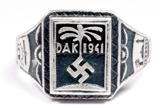 Перстень «Немецкий Африканский Корпус 1941» изготовленный из серебра 835-ой пробы с применением чернения. На его щитке изображена эмблема корпуса – свастика на фоне пальмы, а также надпись «DAK 1941».