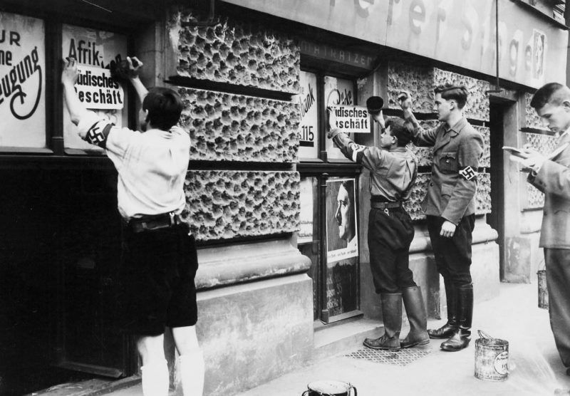 Члены Гитлерюгенд наклеивают антисемитские постеры на еврейские магазины. 1939 г.