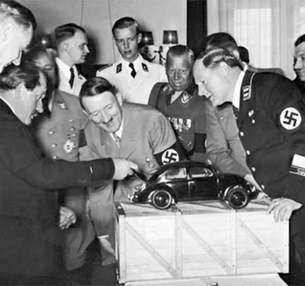 Роберт Лей, Фердинанд Порше и Адольф Гитлер рассматривают модель автомобиля «Жук». 1939 г.
