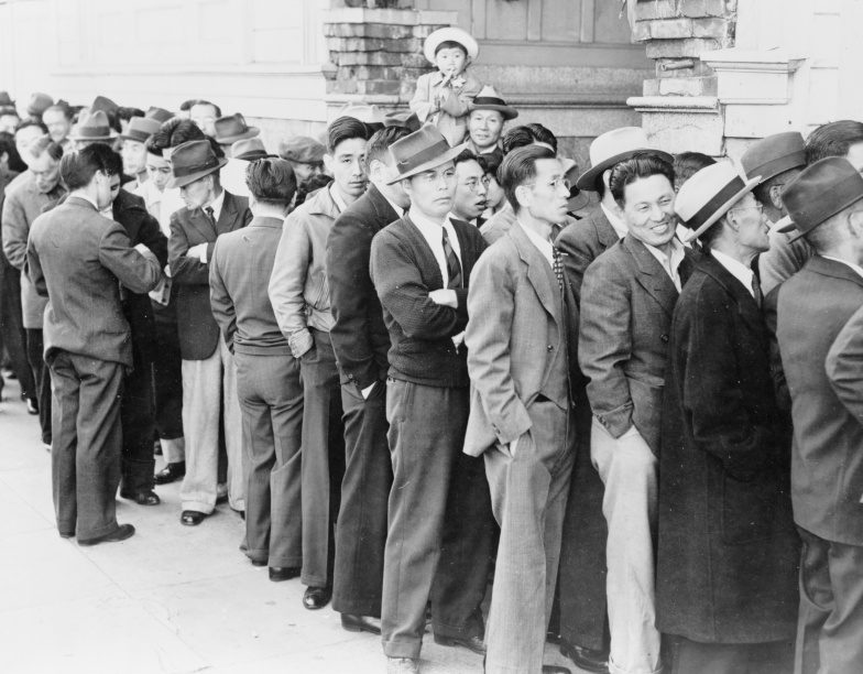 Граждане США японского происхождения стоят в очереди на регистрацию перед отправкой в лагерь для интернированных.