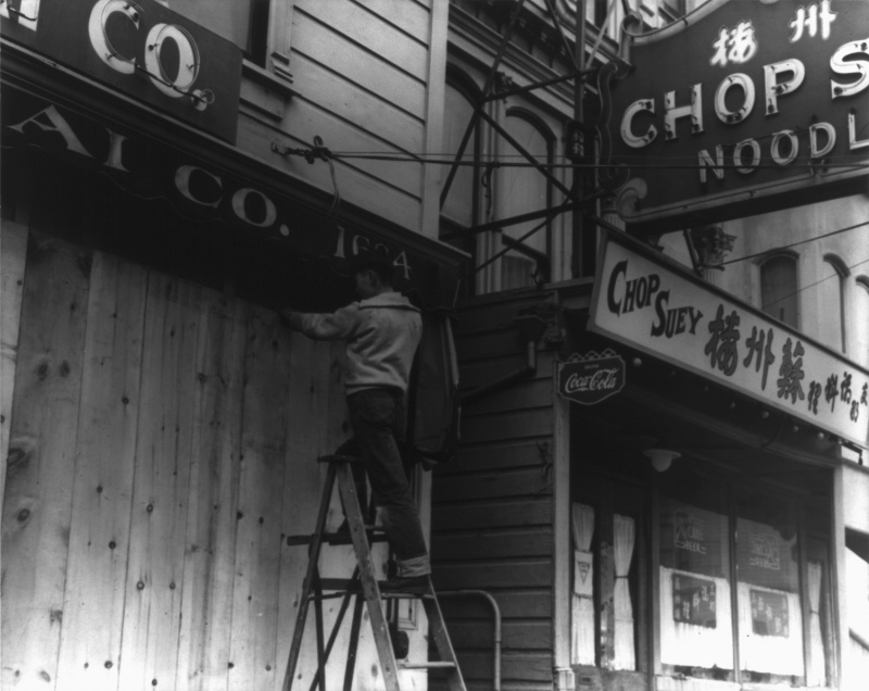 Японец забивает двери своего магазина перед отправкой в лагерь. Апрель 1942 г.