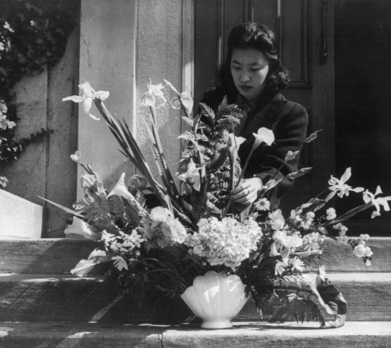 Японка с букетом цветом у порога своего дома перед отправкой в лагерь. Апрель 1942 г.