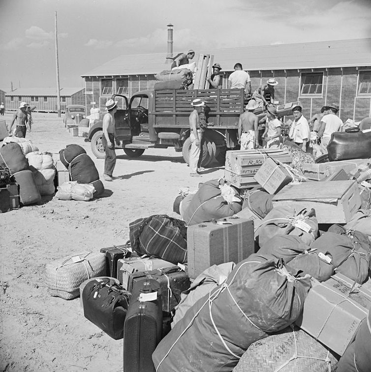 Багаж, интернированных сортируется перед направлением владельцам в бараки. Август 1942 г.