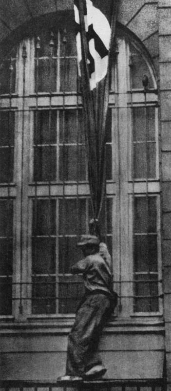 Повстанец срывает немецкий флаг. Август 1944 г.