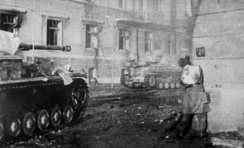 Немецкий военный кинооператор снимает на улице города. Март 1943 г.