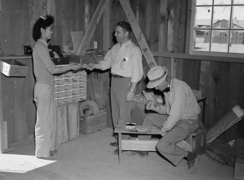 Первый клиент пользуется почтовым отделением в лагере «Постон». 1943 г.