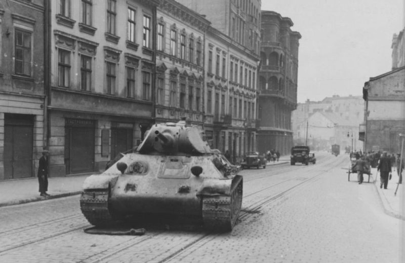 Поломанный танк Т-34 на улице города. Июнь 1941 г.