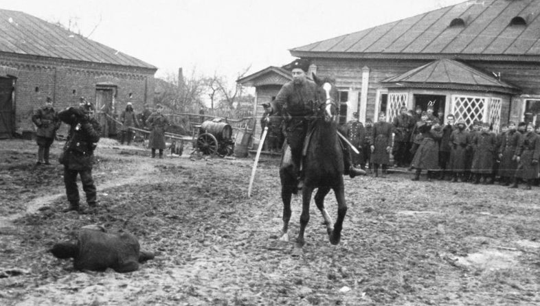 Казак-полицай на потеху венгерским оккупантам рубит шашкой пленных партизан. Ноябрь 1941 г.