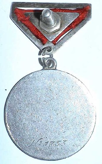 Аверс и реверс Медали «За боевые заслуги» с прорезями обтянутая муаровой лентой на винте.