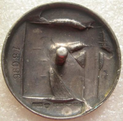 Аверс и реверс серебряного знака «За заслуги» Шюцкора 1-го класса. Изображение руки в доспехе с мечем – позолочено.