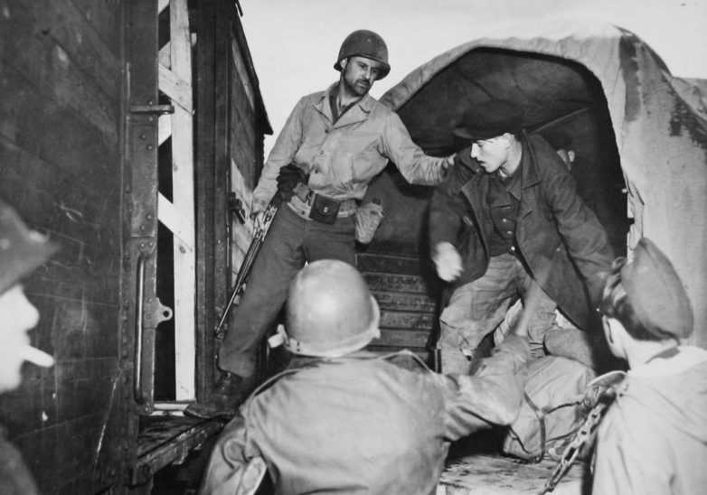 Пленный хиви оказывает сопротивление конвоирам 66-го пехотного полка США, отказываясь переходить из грузовика в железнодорожный вагон, предназначенный для передачи Советской стороне в районе города Хоф. Германия, 1945 г.