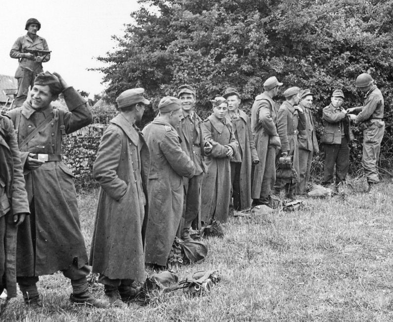 Солдаты 1-й армии США проводят обыск пленных хиви. Июль 1945 г.