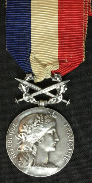 Аверс и реверс серебряной Почетной медали Министерства иностранных дел с мечами.
