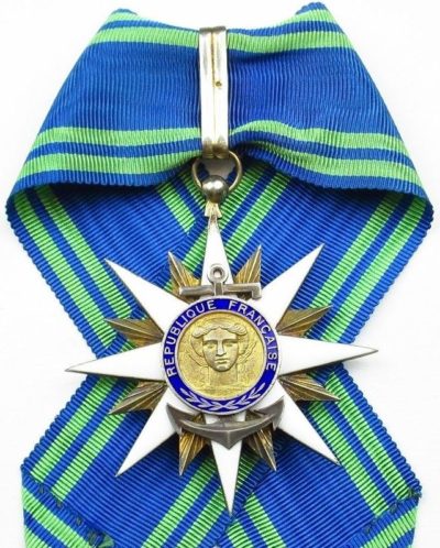 Золотой знак Командора ордена Морских заслуг на шейной ленте.