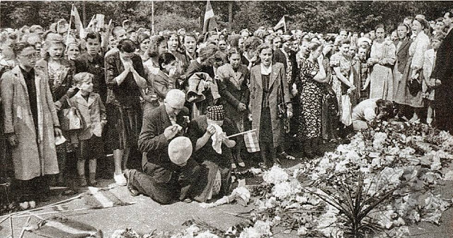 Местные жители возлагают цветы к монументу Свободы после захвата немцами города. Июль 1941 г. 