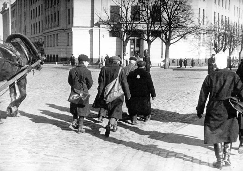 Евреи возвращаются с принудительных работ в гетто, по проезжей части, поскольку ходить по тротуарам им запрещено. Октябрь 1941 г. 