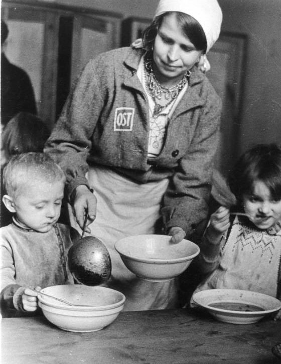 Раздача пищи в детских яслях трудового лагеря. Фотография немецкой пропаганды. Февраль, 1944 г.