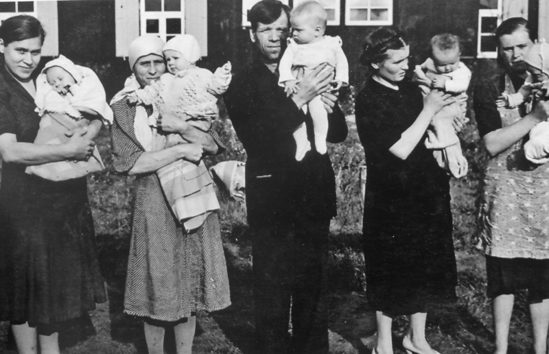 Родители с детьми у барака в лагере для подневольных советских рабочих при автозаводе «Форд» в Кельне. 1944 г.
