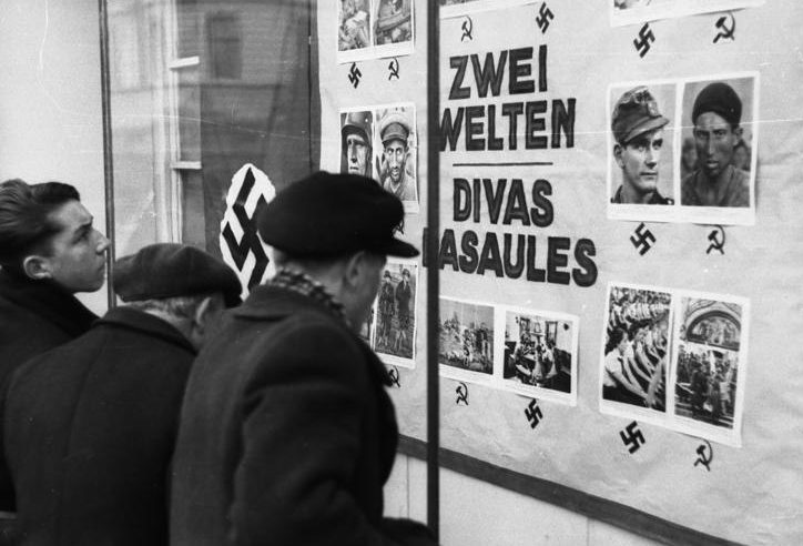 Горожане изучают немецкую агитпродукцию. 1943 г.