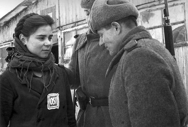 Красноармейцы беседуют с советской девушкой-остарбайтером, работавшей на немецком заводе «Юнкерс» в городе Познани. Польша, февраль 1945 г. 