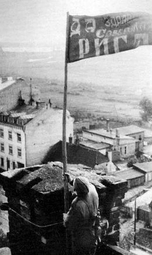 Водружение знамени на одном из зданий освобожденного города. Октябрь 1944 г. 