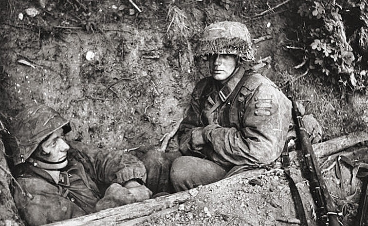 Немецкие пехотинцы в перерыве между боями. Нормандия. 1944 г.