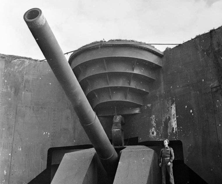 Британский солдат позирует у захваченного 380-мм орудия. Кап-Грис-Нез. 1944 г.