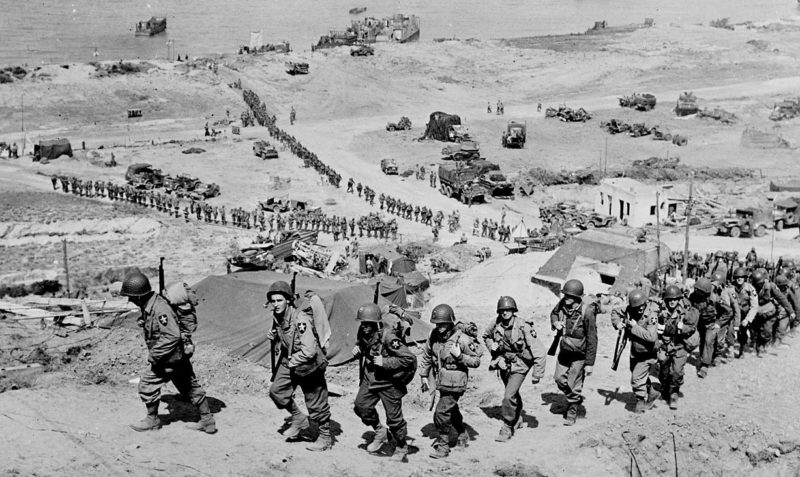 Войска 2-й пехотной дивизии армии США проходят возле немецкого бункера. Омаха-Бич. Июнь, 1944 г.