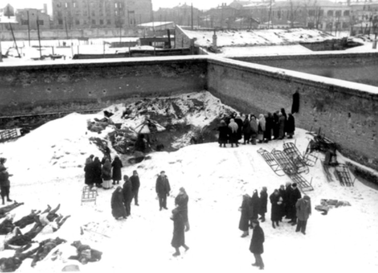 Жители во дворе тюрьмы гестапо опознают родственников, убитых немецкими оккупантами. Февраль 1943 г.