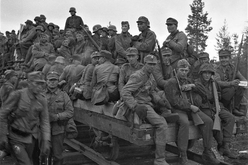 Финские солдаты и солдаты войск СС перемещаются по узкоколейной железной дороге. Июнь 1944 г. 