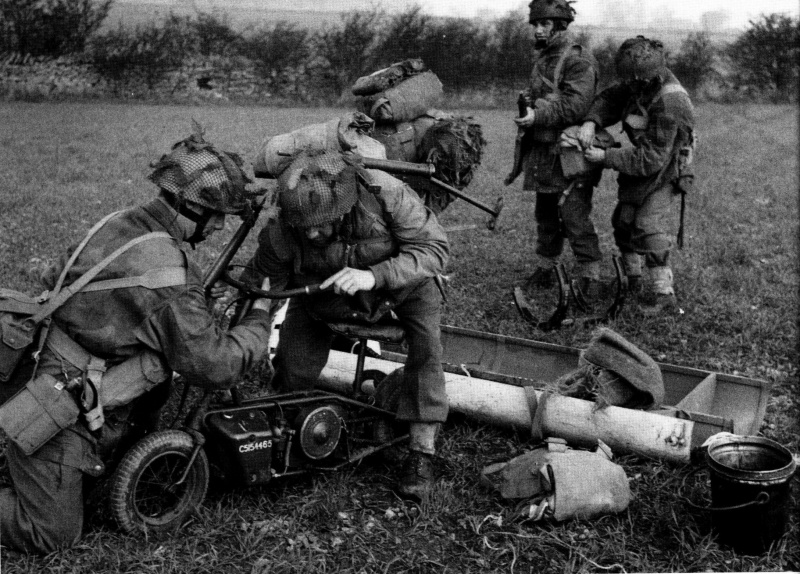 Британские парашютисты обучаются собирать мини-мотоцикл «Welbike», сброшенный в транспортном контейнере. Весна 1944 г.