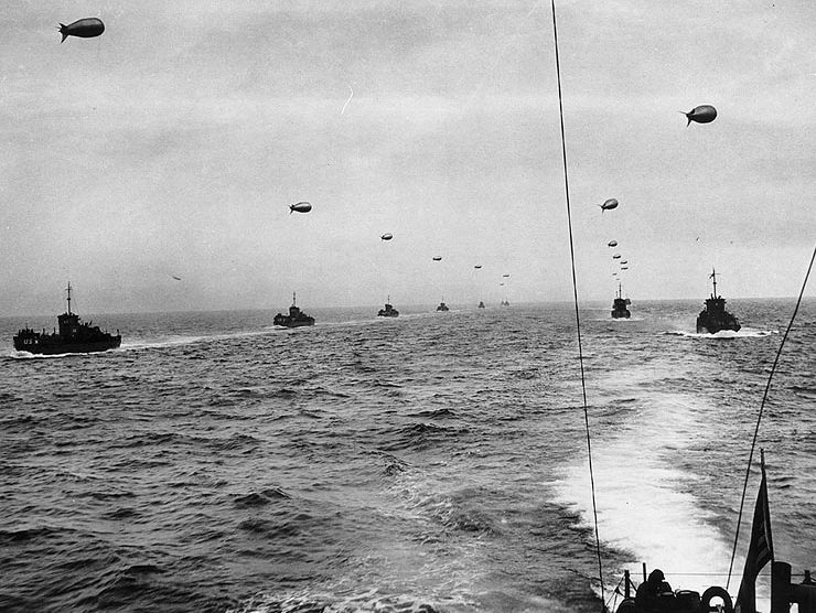 Переход малых десантных кораблей типа LCI(L) через Ла-Манш в направлении Нормандии. К каждому кораблю привязан аэростат ПВО. Утро 6 июня 1944 г.